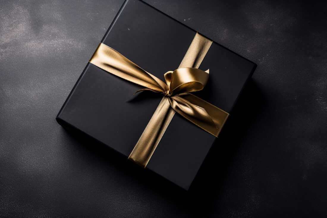 Caixa de presente preta com laço dourado